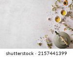 Small photo of Green Tea and Cherry Blossom on white background, top view, copy space. Traditional Japanese cast iron teapot and cups, asian green tea composition with spring sakura bloom.
