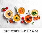 Small photo of Autumn soups. Set of various seasonal vegetable soups and organic ingredients on white background. Homemade colourful seasonal vegan soups.