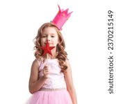 Small photo of Little fairy girl in Halloween pink dress and crown with magic wand putting spell, isolated on white background
