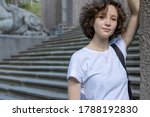 Close up portrait of stylish young woman smiling. Beautiful female model with copy space on old city background enjoying weekend vacation.