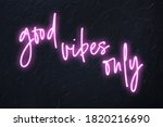 Good vibes only written in pink neon style on black wall background