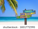 Hapy new year 2021 on a colored wooden direction signs, beach and palm tree background