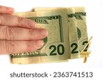 2022 written with dollars bank notes in a hand isolated on white background, new year greetings money concept