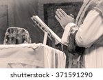 Small photo of Artistic black and white dark vintage edit of a priest saying the extraordinary form, traditional latin tridentine rite Catholic mass. A detail.