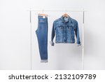 Small photo of blue jeans and jeans jacket closeup on hanger