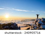 hiker celebrating success on top of a mountain in a majestic sunrise