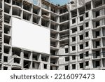 Small photo of White blank information banner mounted on wall of unfinished house on construction site outside