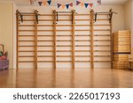Small photo of Swedish wall with wooden ladder mounted in school gym. Interior of sport class room of college or gymnasium.
