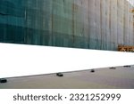Small photo of Blank long white hoarding with space for mockup information located in front of construction site with closed scaffold