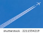 Airplane with contrails against bliue sky
