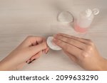 Small photo of woman's hand removes black nail polish with cotton pad dipped in nail polish remover. Close-up shot. Point of view shot. Care of surface of nail plate. Fortified nail polish remover