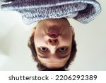 Funny selfie teenage girl with short haircut, upside down. Close up bottom up view of teenage girl happily enjoying moment, surprised posing for selfie, kissing with lips. Generation Z concept