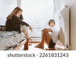 Small photo of Family quarrel, showdown between spouses, scene of jealousy in bedroom. middle-aged married couple, man in underwear sits on floor and holds head, woman is scandalous, jealous, emotionally