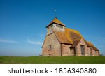 St. Thomas Becket church on a bright sunny afternoon, is an English 13th century religious building which sits isolated on marshland at Fairfield, Kent, part of Romney Marsh. 