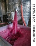 Small photo of Winery producing wine, Grape ju in tank. Wine fermentation tanks. Wine fermentation process Red grapes in fermentation tank. Pouring wine from a tank.