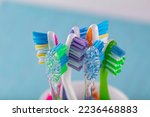 Toothbrushes in ceramic bowl on blurred background. Colorful toothbrushes, healthy tooth concept.