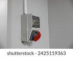 Small photo of Outdoor Electrical Box with Single and Three Phase Current Electrical Appliances and Power Outlets. Three phase connectors. In a factory hall, red and blue, 220 volt and 380 volt sockets.