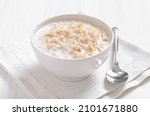 Small photo of Oatmeal porridge in white bowl, close up view.