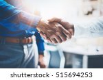 Close up view of business partnership handshake.Concept two businessman handshaking process.Successful deal after great meeting.Horizontal,flare effect, blurred background