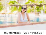 Portrait beautiful young asian woman relax smile leisure around outdoor swimming pool in hotel resort on vacation travel