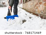 Man removing snow from the sidewalk after snowstorm.