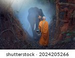 Small photo of Buddhist monks ,Monk walking hiking with canny Elephant in forest