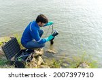 Small photo of A technician use the Professional Water Testing equipment to measure the water quality at the public canal. Portable multi parameter water quality measurement. Water quality monitoring concept.