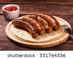 Grilled sausages with sauce ketchup on a wooden table