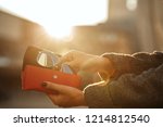 Closeup shot of woman hand opening red sunglasses case at the background of sun. Empty space