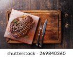Grilled Black Angus Steak Ribeye on Himalayan pink salt block on dark wooden background