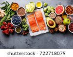 Healthy food clean eating selection: fish, fruit, vegetable, seeds, superfood, cereals, leaf vegetable on gray concrete background copy space
