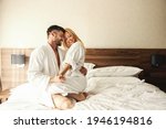 Intimate moments full of love and passion to remember. Happy couple laughing during a holiday stay in a hotel room. Beautiful blonde sitting on her beloved husband's lap, honeymoon, Valentine's Day