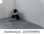 A boy crouching in the corner...