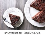 Sliced tasty chocolate cake on wooden table background