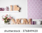 I love mom inscription of wooden letters with heart and flowers on white wall background