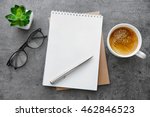 School notebook with glasses and coffee on table