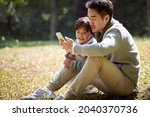 young asian father reading a... | Shutterstock . vector #2040370736