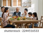 Small photo of multi generational asian family chatting while having meal together at home