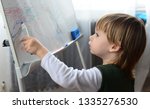 Small photo of little child drawing toddler scrawling on metal board