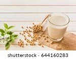Soy milk in glass and soy bean on spoon it on white table background,healthy concept.