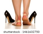 Small photo of Female heels with blister plaster. Band-aid on cloe up on white background.