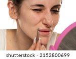 hair over the upper lip in women. girl with tweezers plucks a mustache. female antennae. problem skin.