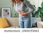 Small photo of Young woman having painful stomach ache. Chronic gastritis. Stomach or menstrual cramps. Abdomen bloating concept.