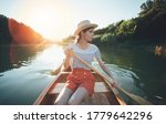 Young Woman Paddling Canoe On...