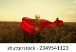 Small photo of Children dreams of becoming superhero. Kids in red cloak, sun. Happy girl, boy play superheroes they run across yellow field in red cloak, cloak flutters in wind. Childrens games, dreams