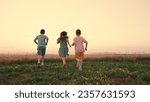 Small photo of Happy childhood. Teenagers play running. Funny children play in park, friends run in summer. Child run on grass, sunset. Happy boy, girl run in field, playing in nature. Family, weekend outdoors.