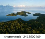 Small photo of Sunrise illuminates calm seas around the islands of Gam and Yangeffo in Raja Ampat, Indonesia. This tropical region is mostly known for its exquisite coral reefs and overall high marine biodiversity.