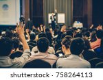 Speaker on the stage with Rear view of Audience in the conference hall or seminar meeting, business and education concept