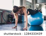 Cinematic tone of young attractive fitness woman exercise with ball in gym. Individual sport to fit muscles of body for healthy life concept.