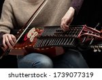 Small photo of Female musician tuning her modern reconstruction of a medieval Swedish nyckelharpa before a performance in close up on the instrument keys and tangents